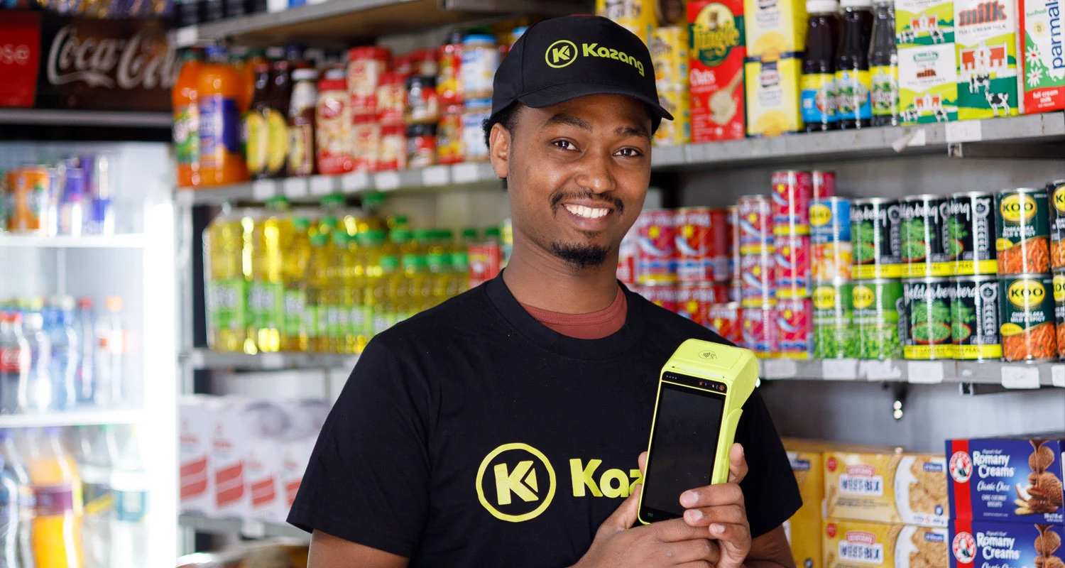 A small shopkeeper using a phone app to order stock in an informal African store
